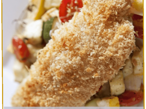A close-up of breaded Saucy Parmesan Chicken garnished with fresh zucchini and cherry tomatoes. The text Saucy Parmesan Chicken is visible, along with a logo reading 3 Boys and a Dog.