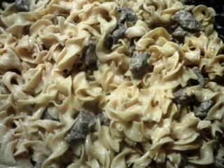 Close-up of a creamy Beef Stroganoff dish, where tender pieces of beef blend perfectly with the noodles in a delightful sauce. The chunks of meat are distributed throughout, creating a hearty and savory meal thats perfect for any creamy recipe enthusiast.