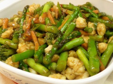 Enjoy a vibrant Shrimp and Asparagus Stir Fry Recipe featuring stir-fried vegetables like bright broccoli and orange carrots, all tossed in a light sauce. This colorful, healthy meal is beautifully presented in a white dish.