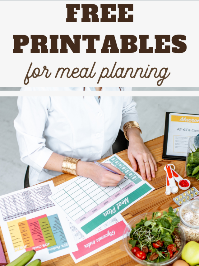 A person in a white shirt sits in a vibrant kitchen, surrounded by fresh vegetables, colorful measuring spoons, and free printables for meal planning. A sign proudly announces the availability of these essential printables to streamline your culinary endeavors.