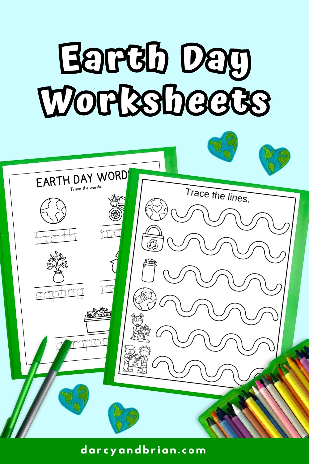 Two Earth Day worksheets, one for tracing words and the other for tracing lines, are shown with two green pencils and colorful crayons below. Background features small globe heart decorations. Earth Day Worksheets text is at the top, offering engaging educational ideas.