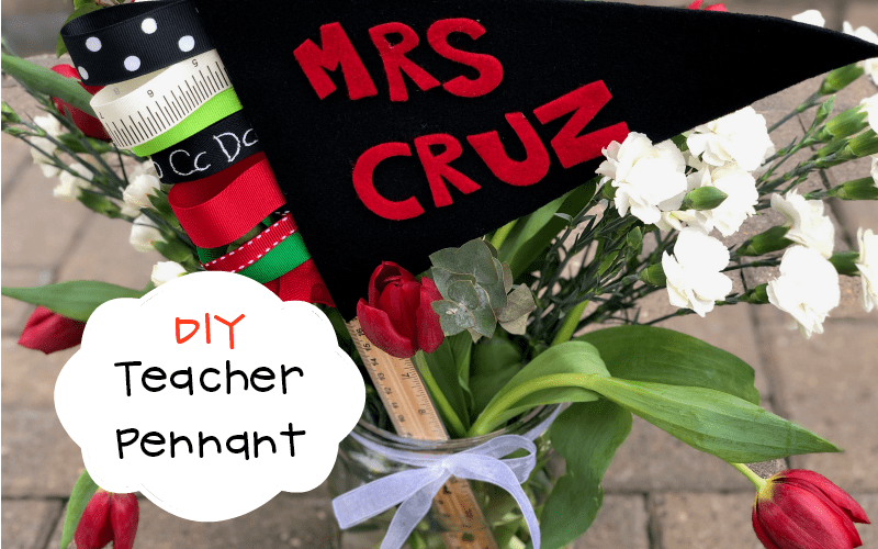 DIY teacher pennant reading “Mrs. Cruz” displayed in a jar with flowers, ribbons, and school-themed supplies.
