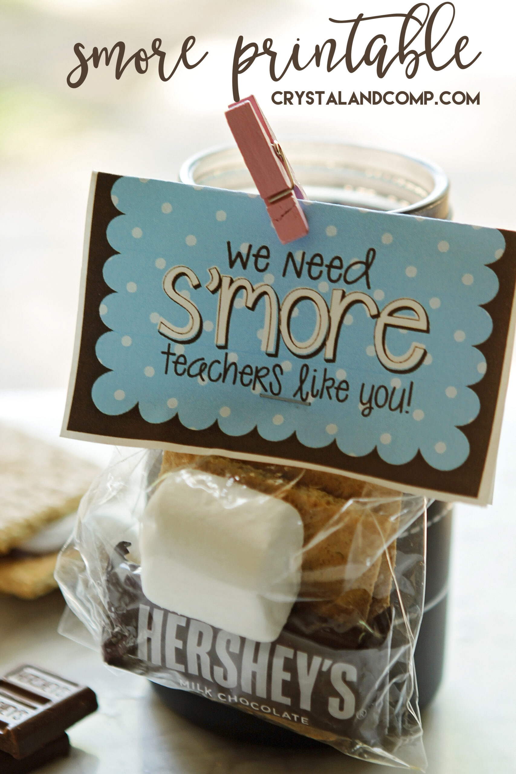 S’mores-themed teacher gift with a printable tag that reads “We need s’more teachers like you,” clipped to a bag with graham crackers, chocolate, and a marshmallow.