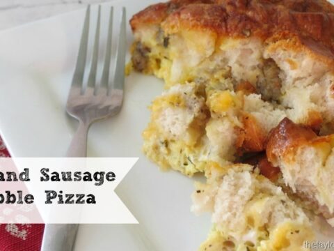 A slice of egg and sausage bubble pizza on a white plate with a fork, nestled on a red patterned napkin. Perfect for breakfast recipes for Christmas morning. Text on the image reads Egg and Sausage Bubble Pizza.