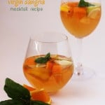 Two clear glasses filled with basil-infused virgin sangria are on display. Each glass contains orange slices, apple pieces, and fresh basil leaves. One glass is shorter while the other is more elongated. The text reads virgin sangria mocktail recipe. A basil garnish is in the foreground.