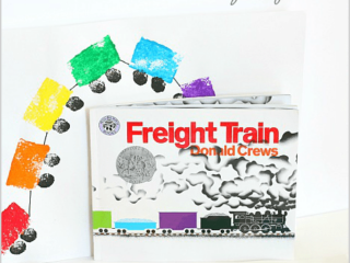 A craft setup features the childrens book Freight Train. Behind it, vibrant sponge-painted train cars, made of rectangles and black circles for wheels, curve around. Text reads Sponge Painted Train Craft for Kids Inspired by Freight Train. Perfect for little ones who love Arkansas crafts!.