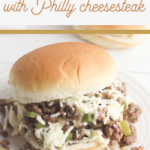 A close-up of a Philly Cheesesteak Sloppy Joe, topped with melted cheese and green bell peppers, served on a bun. Text at the top reads, Sloppy Joes Recipe with Philly Cheesesteak.