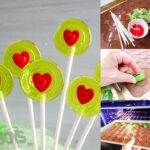 Grinch-themed lollipops made with green candy melts and red heart sprinkles, displayed on a white surface.