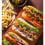 pin of hot dogs on a platter next to french fries with "30 Famous Connecticut Recipes"