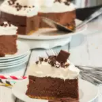 slice of s'mores cheesecake topped with chocolate shavings on a white circle plate
