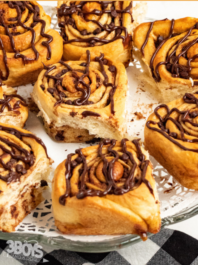 pin image that reads cinnamon rolls with chocolate chips and a cake plate full of baked cinnamon rolls
