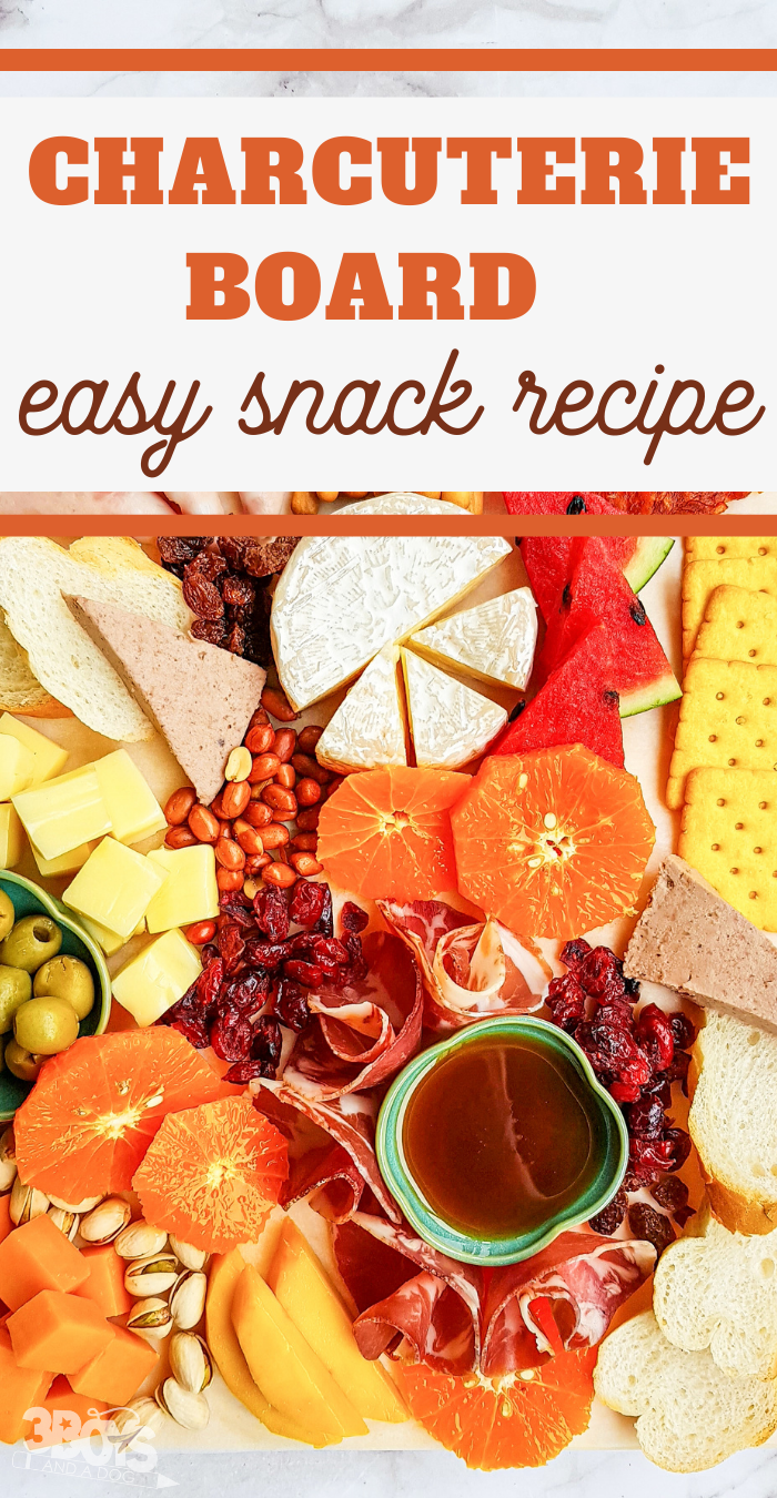 pin image that reads charcuterie board, easy snack recipe with a close up of cheese, meat, crackers, and other ingredients