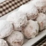 plate of stacked powdered sugar donut holes
