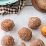 pin image that reads donut holes easy breakfast with a lot of cinnamon sugar donut holes and a spoonful of cinnamon sugar