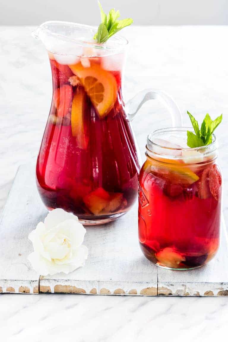 Non alcoholic sangria mocktail with chopped fruit in a pitcher