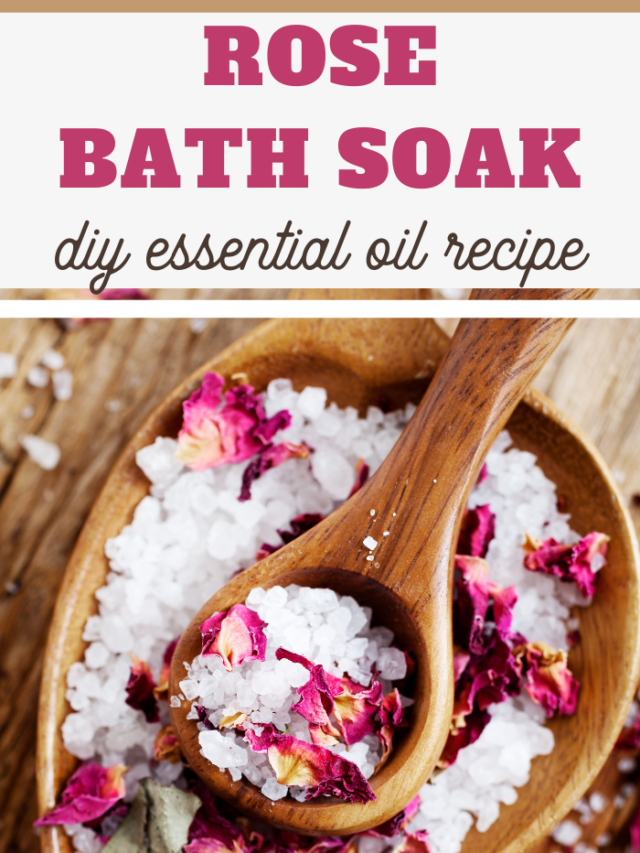 A wooden bowl filled with white bath salts and dried rose petals is accompanied by a wooden spoon. The image features text reading Rose Bath Soak, showcasing a DIY preparation on a rustic wooden background.