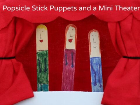 Red curtain opens to reveal three popsicle stick puppets, each with drawn-on faces and colorful clothing, set against a red background. The text reads Popsicle Stick Puppets and a Mini Theater.