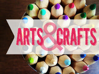 A top view of a group of colored pencils arranged in a circular pattern with the words ARTS & CRAFTS in bold pink and white text overlaying the image. The pencils vibrant tips form a colorful and artistic display.