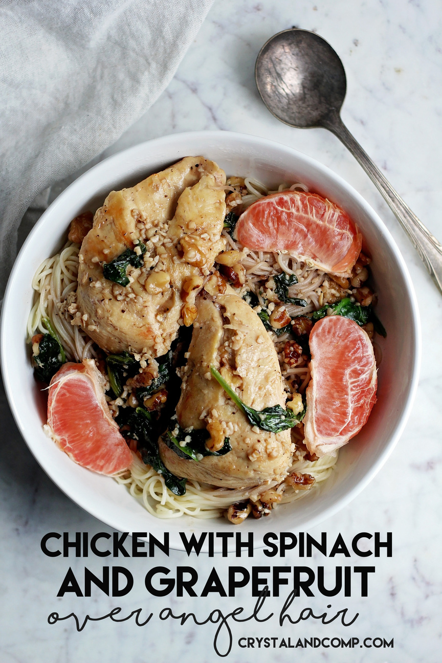 A bowl of angel hair pasta topped with chicken, spinach, walnuts, and grapefruit slices. A fork rests on the side of the bowl. Text reads: Chicken with Spinach and Grapefruit over Angel Hair along with a website URL at the bottom.