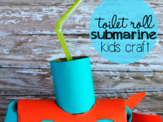 Homemade kids craft of a submarine made from a toilet roll. The body is orange with blue accents and a blue periscope made from a straw. Text reads toilet roll submarine kids craft on a wooden background.