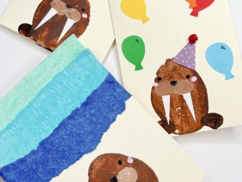 Three handmade cards featuring walrus designs. One card has a walrus with a striped background, another with a walrus in a party hat surrounded by colorful balloons, and a third with a single walrus. The Red Ted Art logo is visible.
