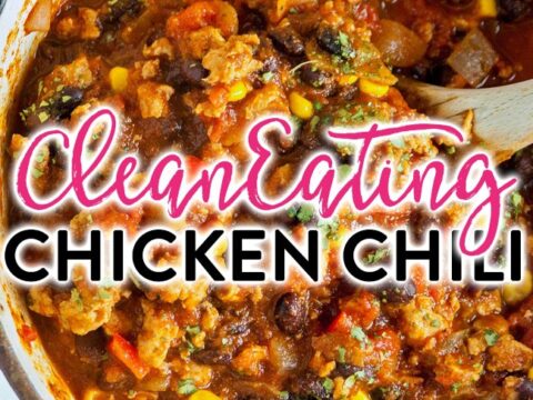 A pot of chicken chili with visible ingredients like beans, corn, and tomatoes. A wooden spoon rests in the pot. Text overlay reads, Clean Eating Chicken Chili in stylized font.