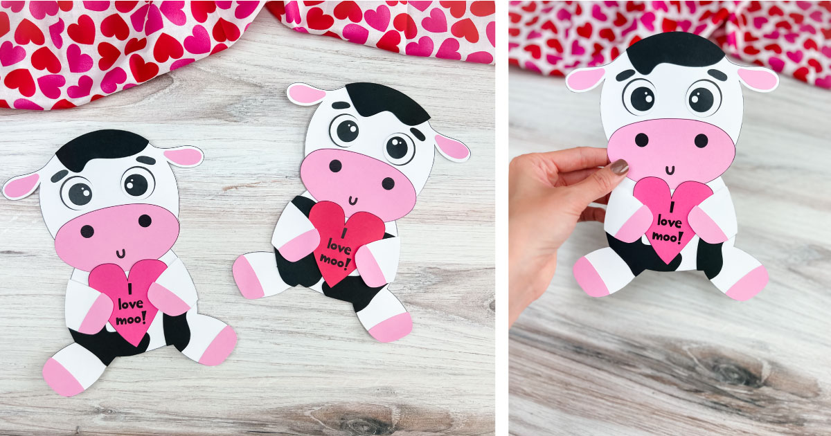 Two paper cows with pink noses and ears, each holding a red heart with I love moo! written on it, are displayed on a wooden surface. A hand holds one cow. A heart-patterned cloth partially appears in the background.