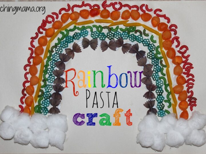A craft project featuring a rainbow made from colored pasta shapes, including shells, spirals, and bow ties, arranged on paper. Rainbow Pasta Craft is written in colorful letters beneath it. Fluffy cotton balls form clouds at the ends.