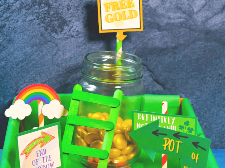 A playful setup with a jar of gold candies labeled Free Gold on a rainbow-colored board, perfect for leprechaun trap ideas. Signs read End of the Rainbow and Pot of Gold, while a small green ladder tempting any wandering leprechaun leans against the jar.