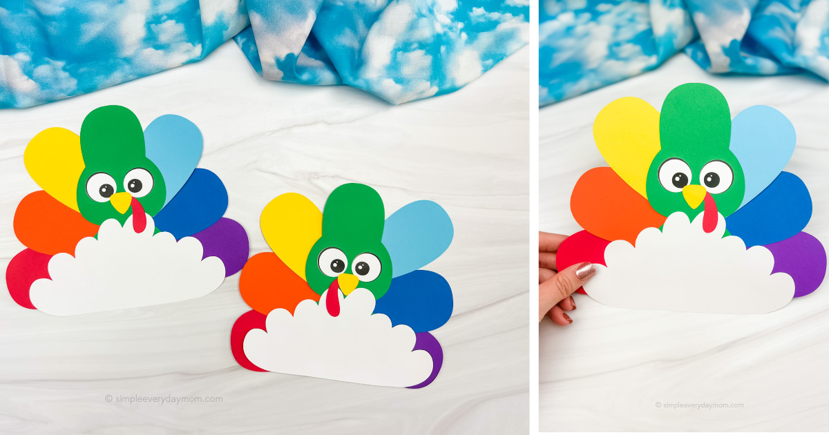 Two colorful turkey crafts made of paper with rainbow tail feathers. Each turkey has a green head, googly eyes, and an orange beak, set against a marbled white surface. A hand holds one turkey on the right. Blue and white fabric in the background.