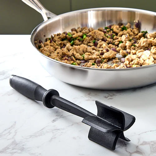Pampered Chef Mix 'N Chop beside a skillet of browned ground meat