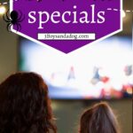 Parent and child watching television beneath a purple graphic that reads “Kids’ Halloween Specials” with orange Halloween lettering and a spider.