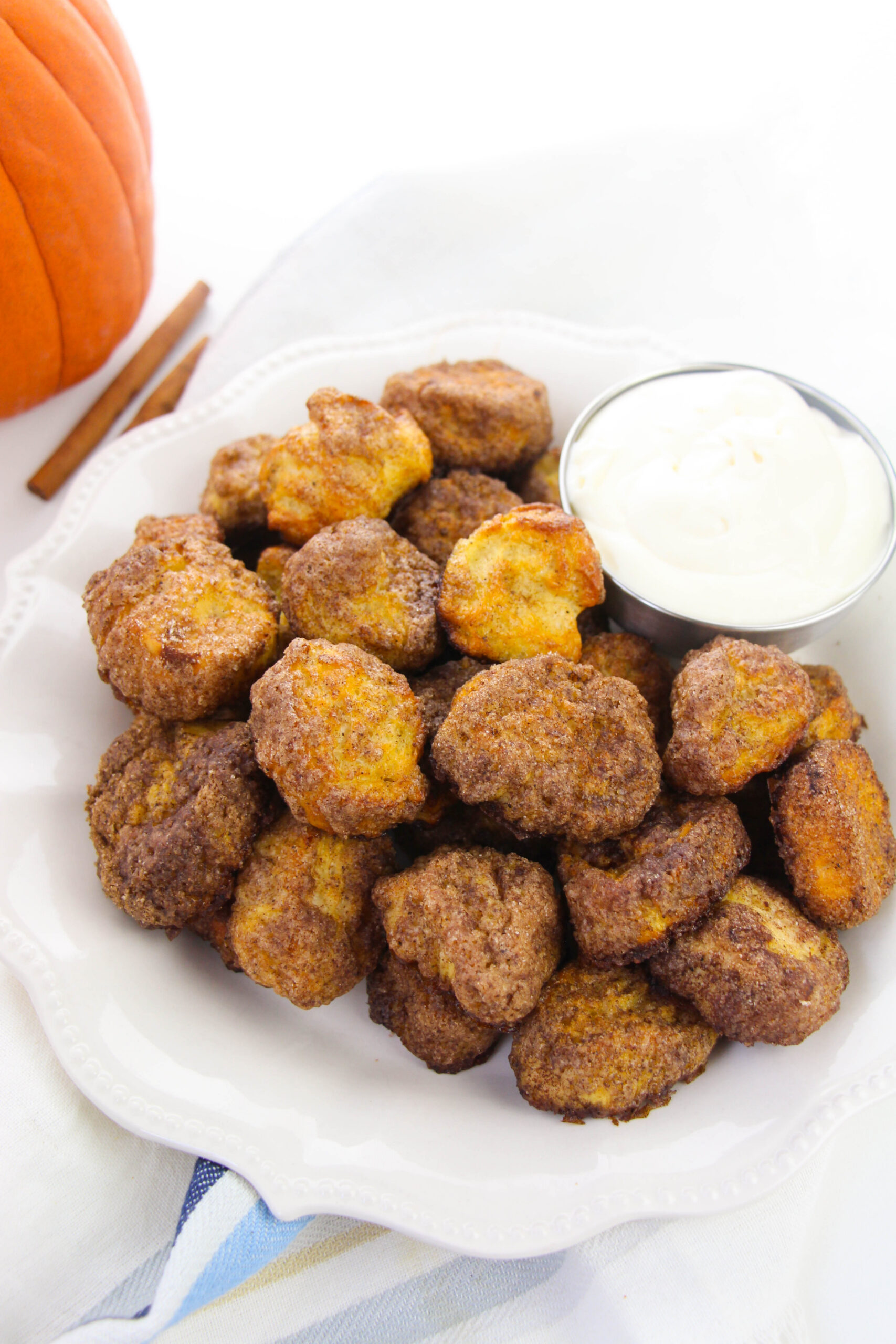 Pumpkin spice pretzel bites coated in cinnamon sugar on a white plate