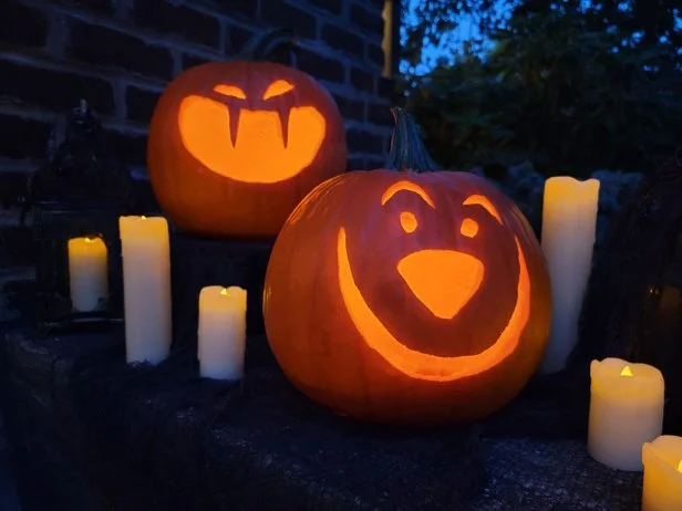 Carved jack-o-lantern faces lit up in the dark