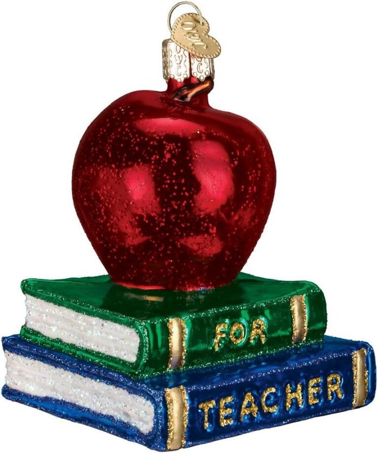 Glass blown red apple ornament sitting on a stack of books