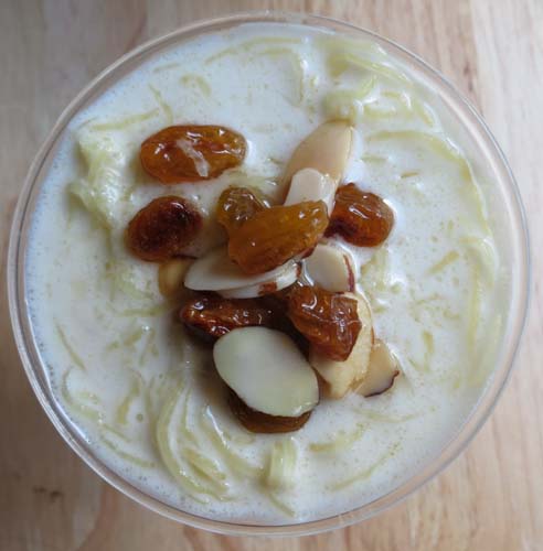 Spaghetti squash kheer, a creamy coconut milk pudding topped with golden raisins and sliced almonds