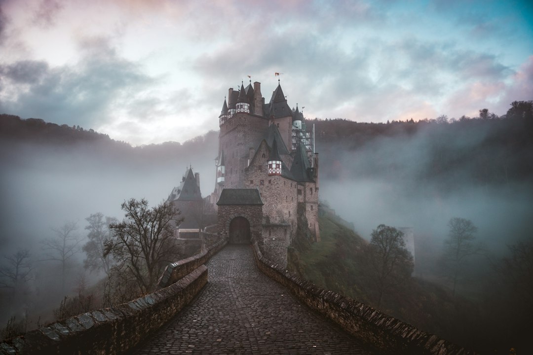 Old stone castle on a hill wrapped in morning fog