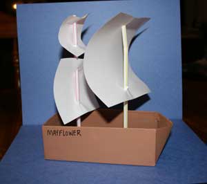 Small cardboard box painted brown as a Mayflower ship with paper sails
