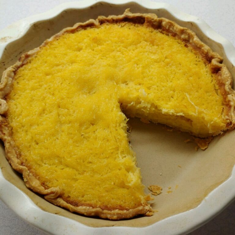 A slice of mock coconut pie made with shredded spaghetti squash in a golden pie crust